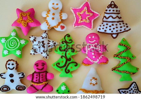 Christmas composition: cookies in the shape of a Christmas tree, gingerbread man, bells and colorful stars decorated on a yellow background