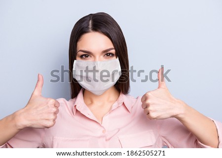 Close-up portrait of pretty content girl wearing safety mask showing double thumbup therapy mers cov isolated on gray color background