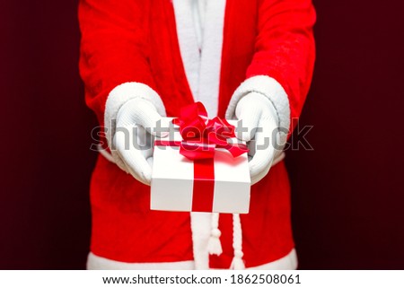 Cropped view of santa claus holding gift box.Close up front view selective focus.Christmas concept.
