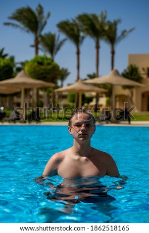 Real people concept, beautiful young man, teenage boy swimming and having fun in pool in vacation. happiness and nice body for enjoyed people live an alternative lifestyle as vacation