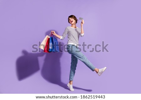 Full length photo of charming buyer woman wear casual outfit holding colorful shopping bags credit card isolated violet color background