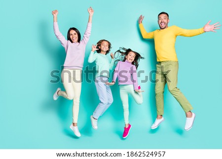 Photo portrait of full family jumping up together isolated on vivid turquoise colored background