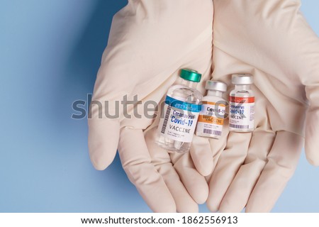 COVID-19 Vaccines for developing country concept. Hand of a Researcher holding Coronavirus 2019-nCoV Vaccine vials. Together, Financial Support poor nations, Alliance, Unicef, WHO, G20, promised. Royalty-Free Stock Photo #1862556913