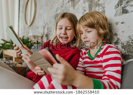 Boy and girl using tablets in Christmas time
