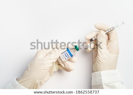 Covid-19, 2019-nCoV vaccination development concept. Beautiful close up - Doctor's hands in medical latex gloves takes shot from Coronavirus Vaccine vial by sterile needle syringe. Phase 3, FDA, WHO. Royalty-Free Stock Photo #1862558737