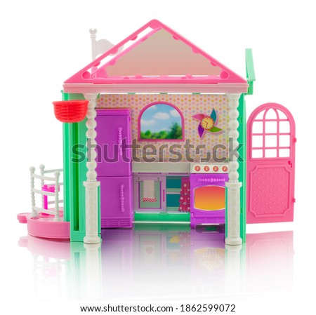 cute children's little house - a toy. Plastic dollhouse. Small house with kitchen, stove, oven, terrace, door, clock and refrigerator. Isolated on white background with shadow reflection. 