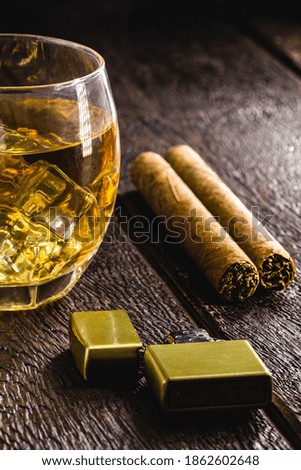 glass of whiskey with ice and cigar, strong drink, concept of relaxing moment, smoking