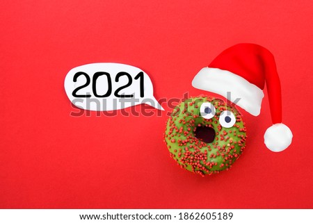 christmas new year donut santa claus with party hat. for present card or invitation of party. festival red background with number 2021