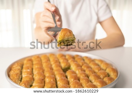 Detail of the hand of a woman serving baklava dessert Royalty-Free Stock Photo #1862610229