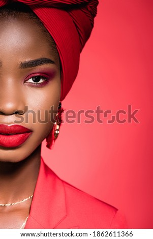 cropped view of african american young woman in stylish outfit and turban isolated on red Royalty-Free Stock Photo #1862611366