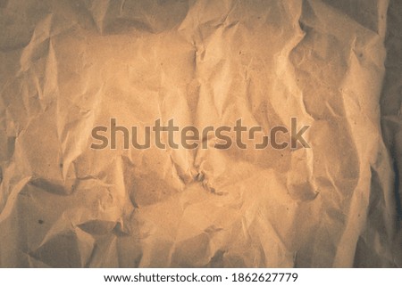 Background with brown crumpled sheet of fabric with vignette