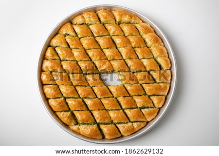 Baklava dessert in a tray sliced in a triangle from traditional Turkish cuisine Royalty-Free Stock Photo #1862629132