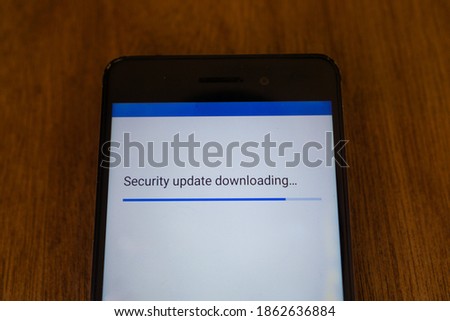 security update downloading in progress for smartphone with blurry wood texture background