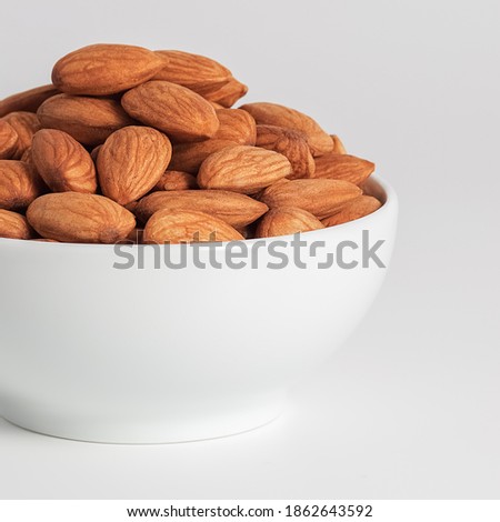 Almond in white cup on white background.
