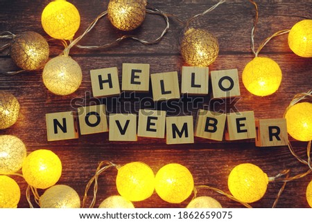 Hello November alphabet letter with LED cotton balls on wooden background