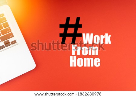 WORK FROM HOME text with laptop on red background. Business and Copy Space Concept