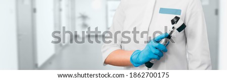 Dermatologist with a dermatoscope stands in the hospital corridor. Concept preventive examination of human skin problems in dermatology Royalty-Free Stock Photo #1862700175