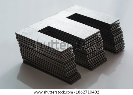 Ferromagnetic metal core for high energy efficient transformer. Ferrite transformer for switching power supply. Selective focus, shallow depth of field. Royalty-Free Stock Photo #1862710402