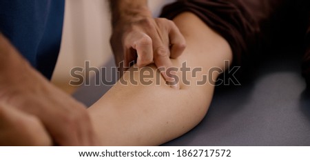 An osteopath during manual therapy treatment on a patient presses a painful area and releases a blockage. Royalty-Free Stock Photo #1862717572