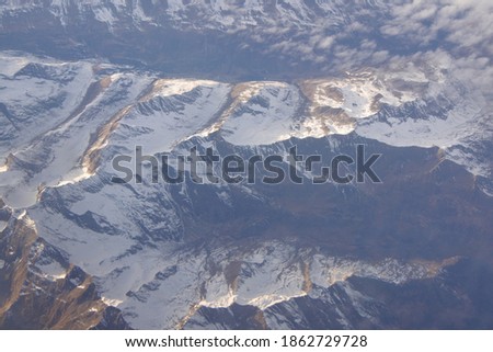 Snow top mountains captured from a airplane