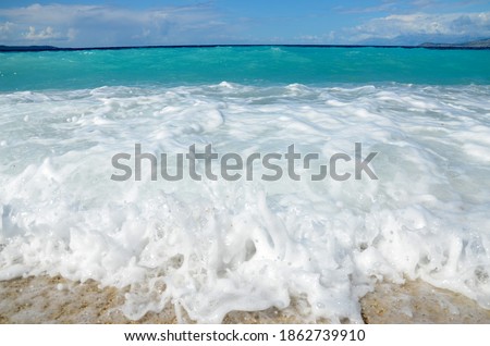 Huge waves crushing on tropical beach with yellow sand. Waves breaking on the shore. Coastline. Beautiful sandy beach at summer. Deep blue sea. Wonderful nature. Paradise wild beach. Splashing water. 