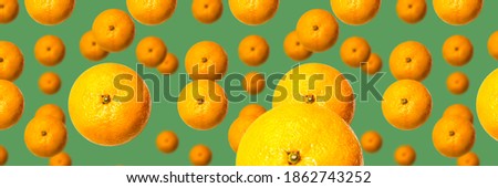 Falling tangerines on a green background. Banner, postcard, wallpaper.