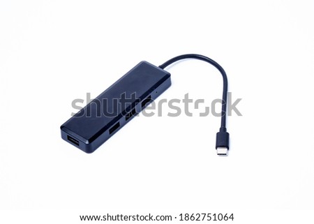 The black color of the multi USB type-c hub converter to the laptop. Isolated on a white background