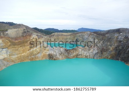 photo picture of a beautiful amazing delightful volcanic multicolor lake in the crater of a volcano Lake Kelimutu National Park Island of Flores against the backdrop of a wonderful skyline