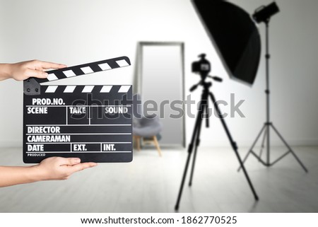Assistant holding clapperboard on filming location, closeup. Cinema production  Royalty-Free Stock Photo #1862770525