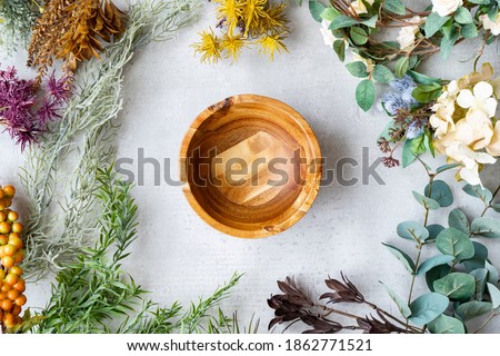 Wooden plate and botanical ornaments set on a marble table Royalty-Free Stock Photo #1862771521