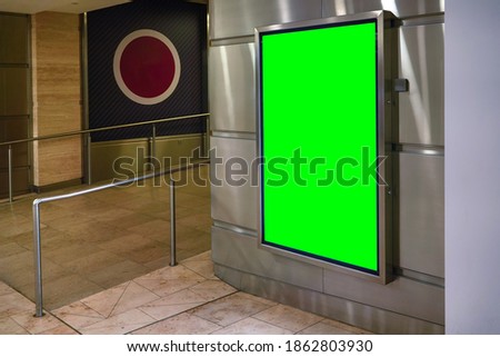Wall with light display ad board - green color advertisement mock up, steel rail near