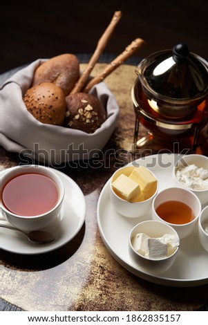 Hotel breakfast set on table with honey, tea, bread and butter. 