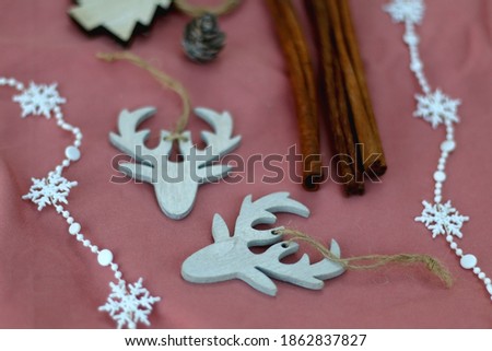 Various Christmas decorations and cinnamon sticks on pink background. Selective focus.