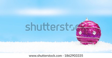 Winter holidays background with a purple bauble