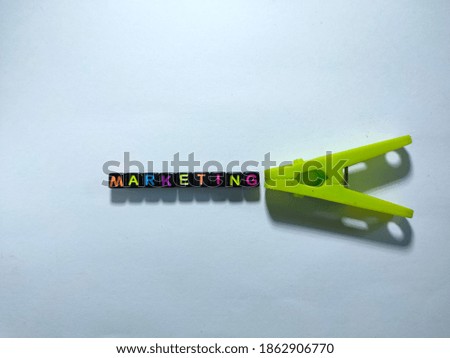 Selective focus.Black bead with color letter in word MARKETING with white background.Business and finance concepts.