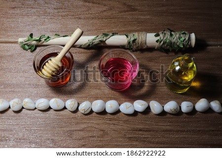 A witch ritual, a spell using runes, honey, flower water, herbal oils and magic wands. This picture is used to compose an article on magic.