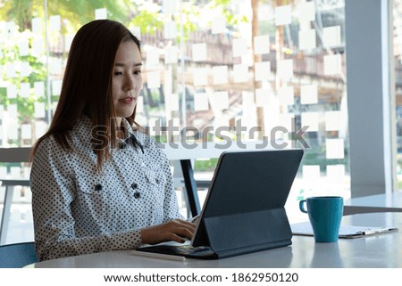 Cropped shot of female hand typing on tablet keyboard on white worktable