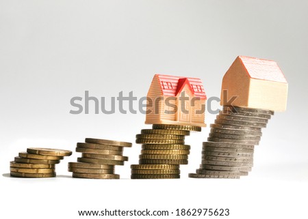 Crashing or falling of the real estate market concept with coins and homes model disposed in a ladder Royalty-Free Stock Photo #1862975623