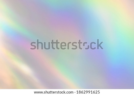 Blurred rainbow light refraction texture overlay effect for photo and mockups. Organic drop diagonal holographic flare on a white wall. Shadows for natural light effects Royalty-Free Stock Photo #1862991625