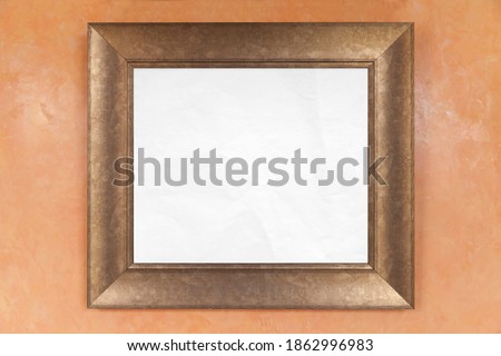 Empty wooden frame with copy space area of blank white paper is on a wall, background texture