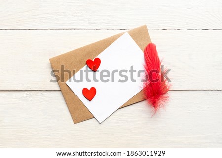 greeting card template with craft paper envelope and bright red hearts and feather. card text design for social media blogs.