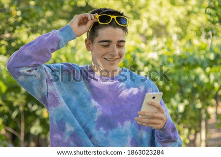 young teenager outdoors with mobile phone and sunglasses