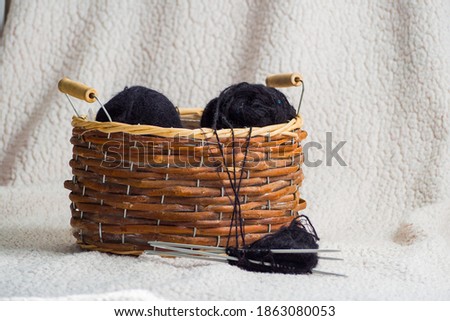 Balls of black yarn in a basket.