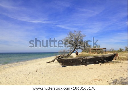 The picture was taken on the Kinburn Spit, near the town of Ochakov. The photo shows a deserted seascape with an old boat.