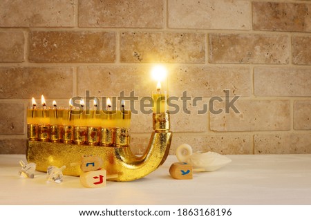 Image of jewish holiday Hanukkah with menorah (traditional Candelabra) and wooden dreidel (spinning top)
