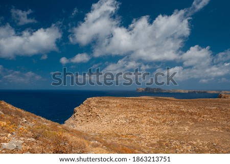 the shore of the exotic clear sea and the waves break on the rock and in the background is a mountain and clouds and a blue sky during the day