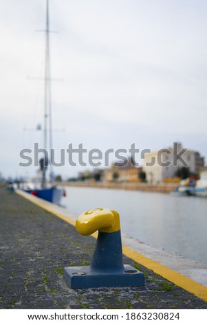 Yellow and blue mooring bollard without a sea rope