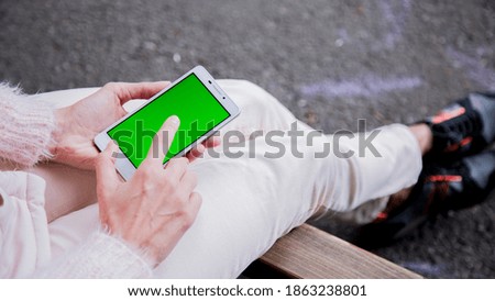 Women holding a phone in the park