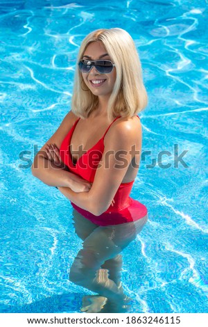 A gorgeous young blonde model poses in a bikini while enjoying a summers day