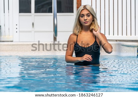 A gorgeous young blonde model poses in a bikini while enjoying a summers day